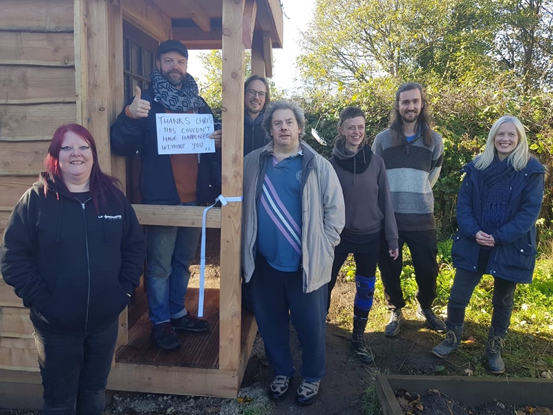 Volunteers and staff stood by the new compost toilet smiling